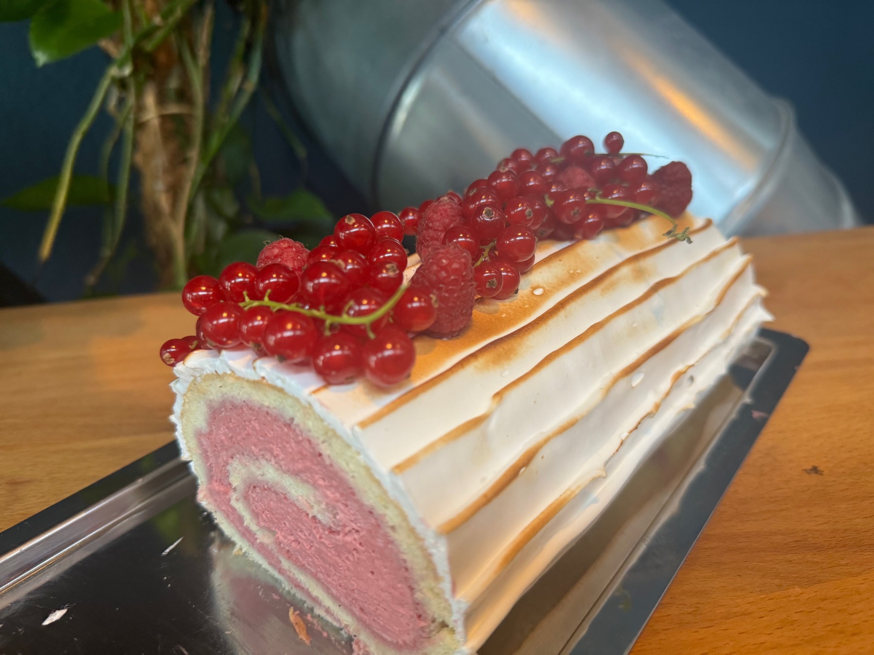 Raspberry sponge roll with flambéed meringue and fresh berries