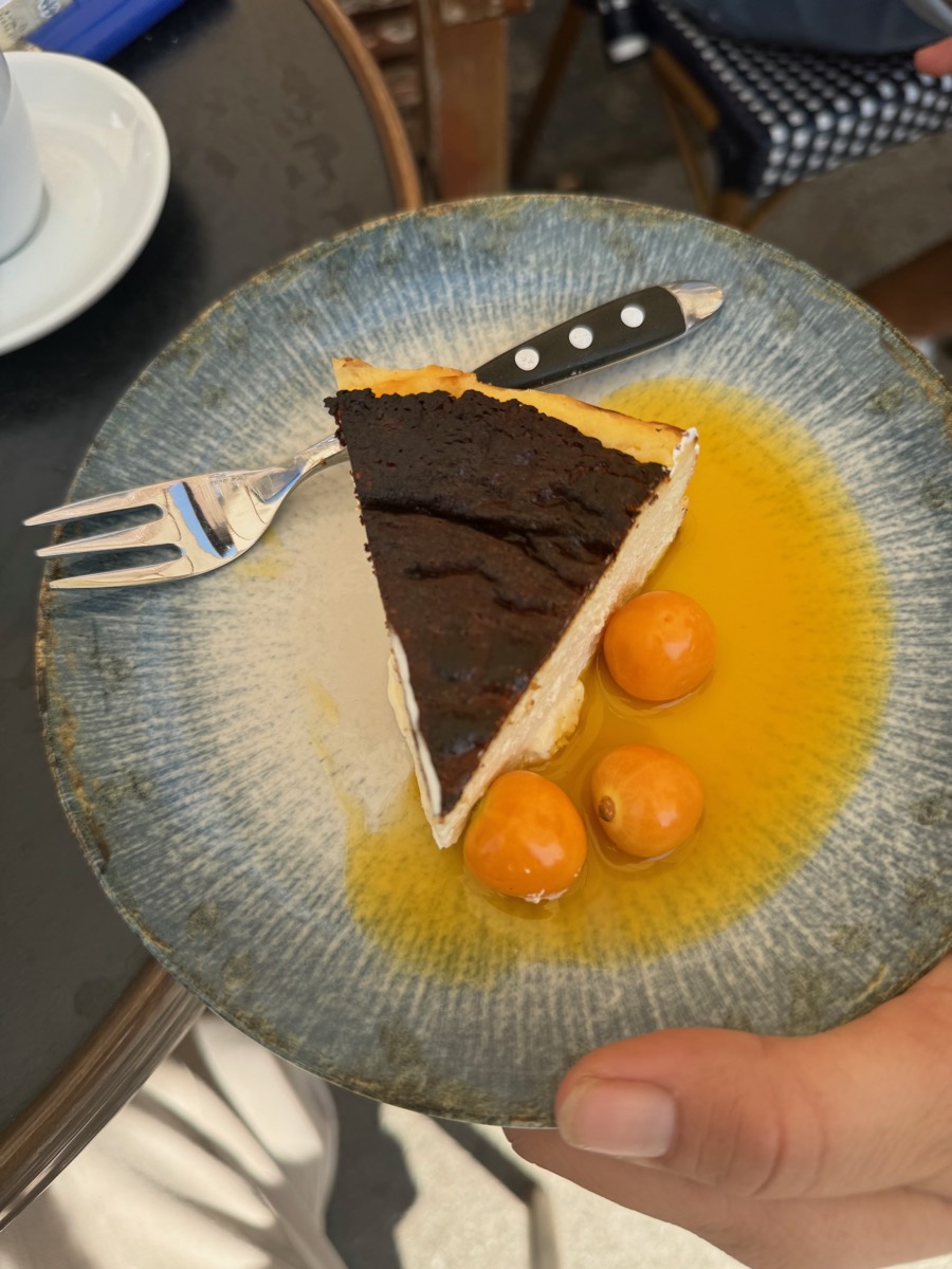 Slice of cheesecake with physalis and fruit sauce on a blue plate