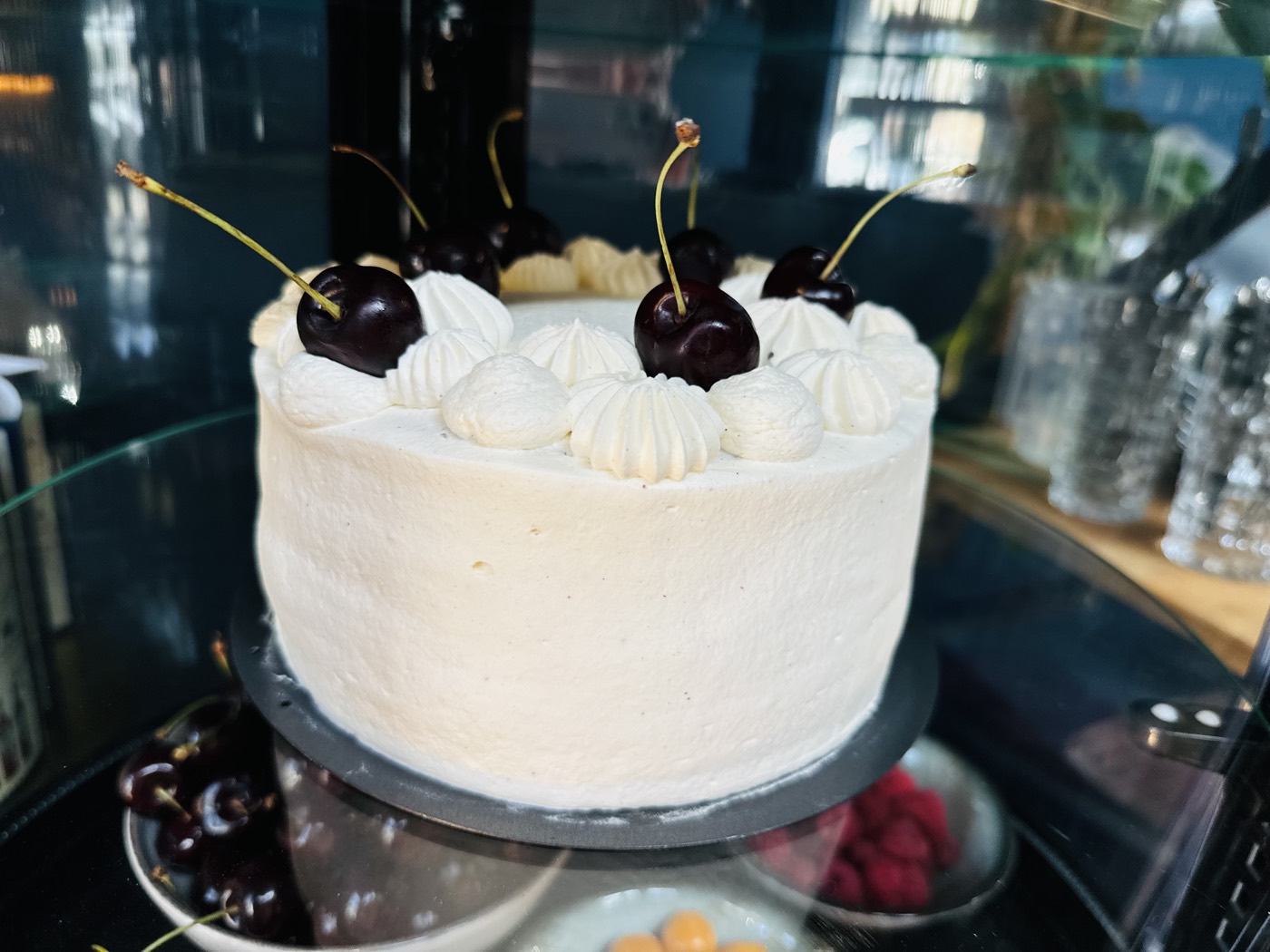 Cream cake with fresh cherries in the counter display