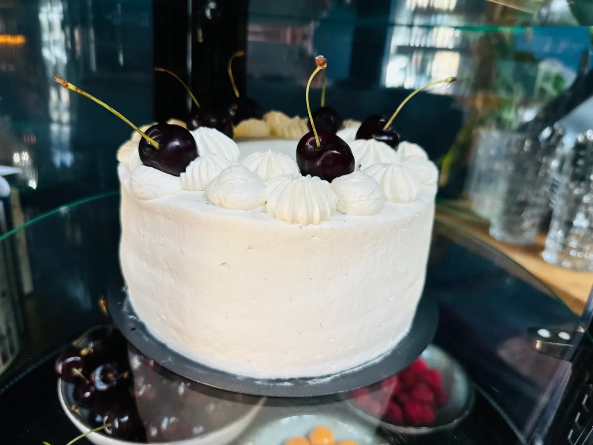 Sahnetorte mit frischen Kirschen in der Kuchentheke