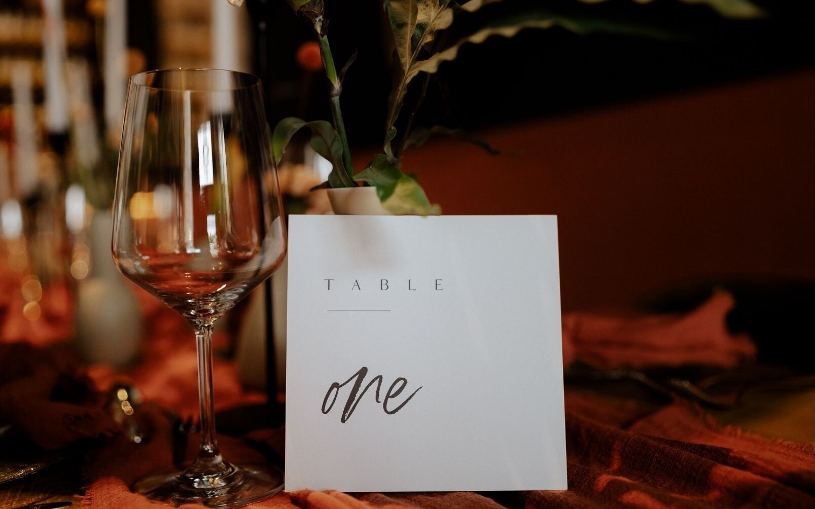 Elegant table decor with wine glass and table card at a wedding in the THE DUKE distillery